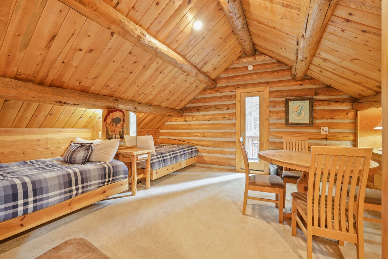 Rustic log cabin charm meets cozy comfort in this inviting loft space—your mountain retreat with vaulted ceilings and natural wood warmth all around.