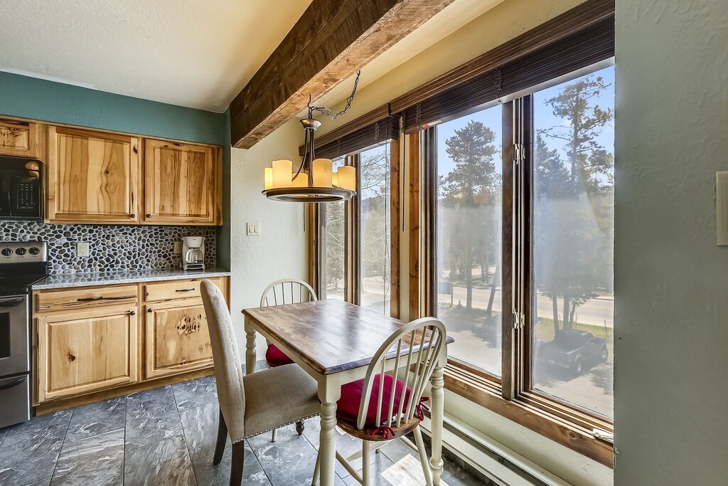 Enjoy morning coffee at your rustic dining table, surrounded by warm wood and natural light streaming through expansive windows.