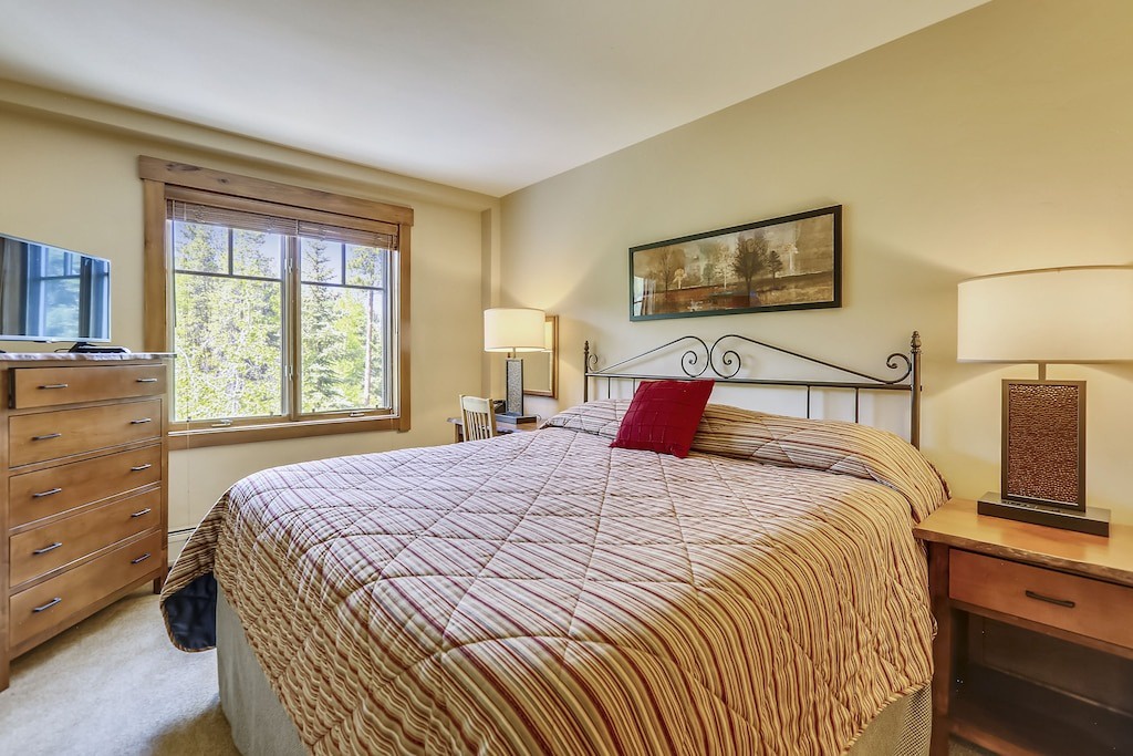 Rest peacefully in your comfortable bedroom with crisp linens, natural light, and mountain views through large windows.