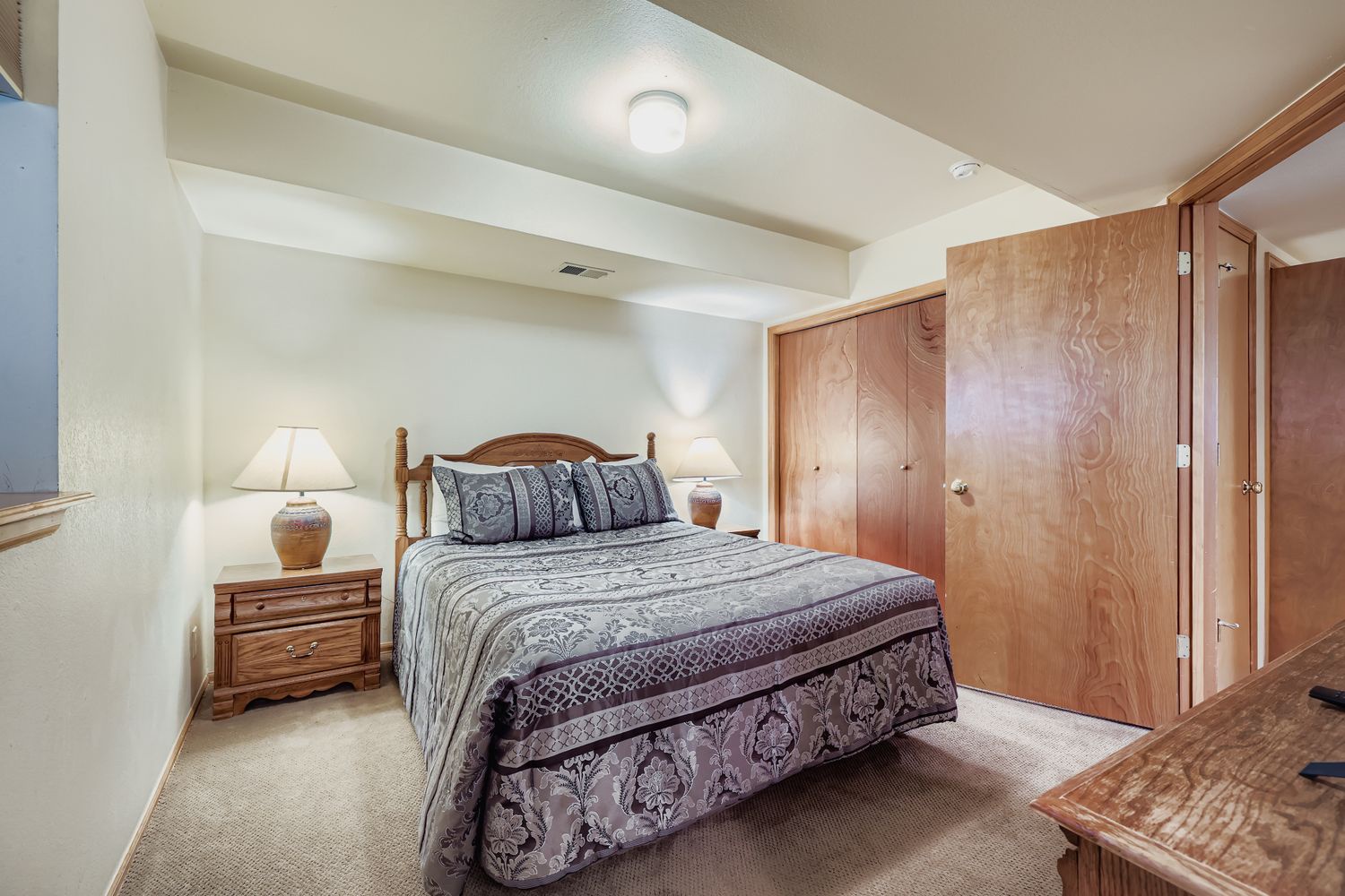 Cozy bedroom with warm wood accents and traditional decor, offering your peaceful retreat with ample storage.