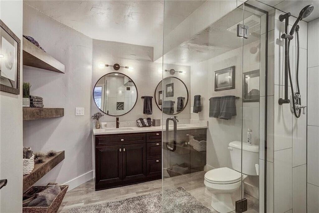 Step into your spa-like bathroom with dual vanities, glass-enclosed shower, and stylish floating shelves for all your essentials.