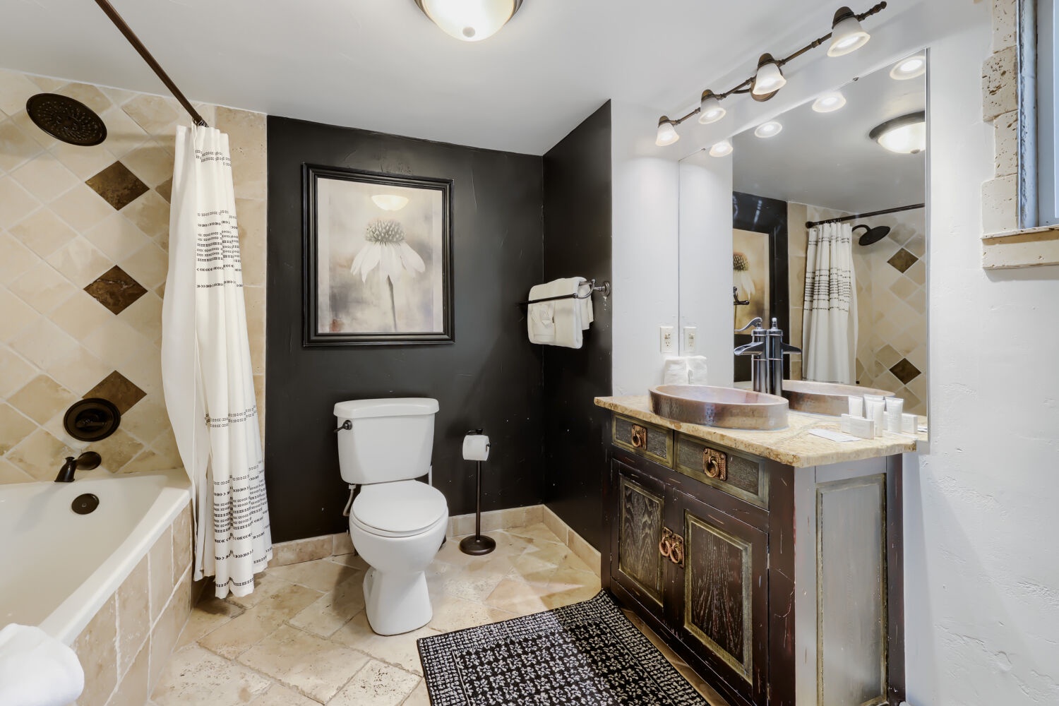 Beautifully designed bathroom featuring elegant tilework, custom vessel sink, and soothing ambiance with plush towels and thoughtful décor for the ultimate retreat experience.