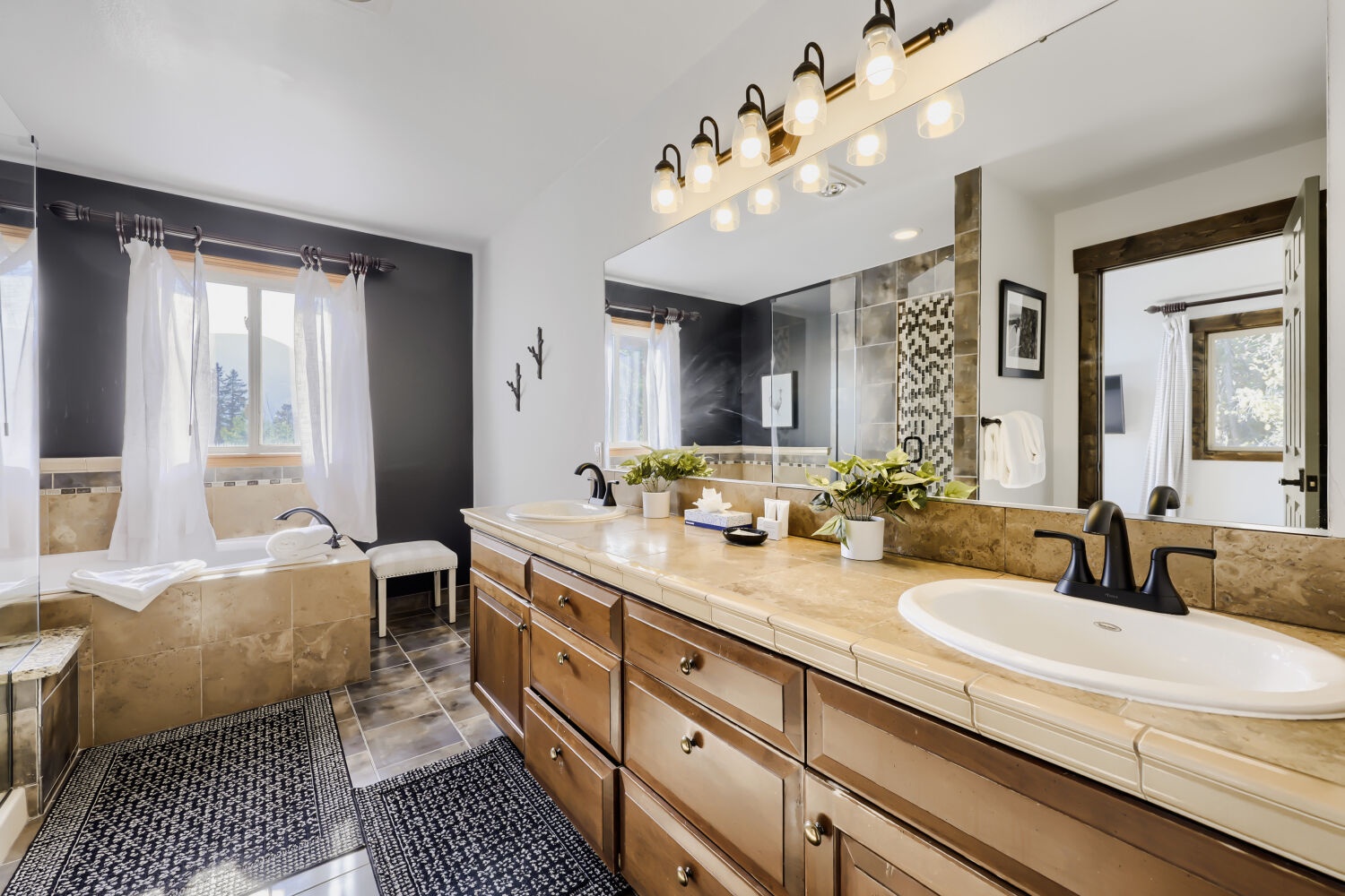 Unwind in your luxurious spa-like bathroom featuring dual vanities, elegant soaking tub, and sophisticated lighting. Natural light and warm finishes create the perfect sanctuary for your morning and evening routines.