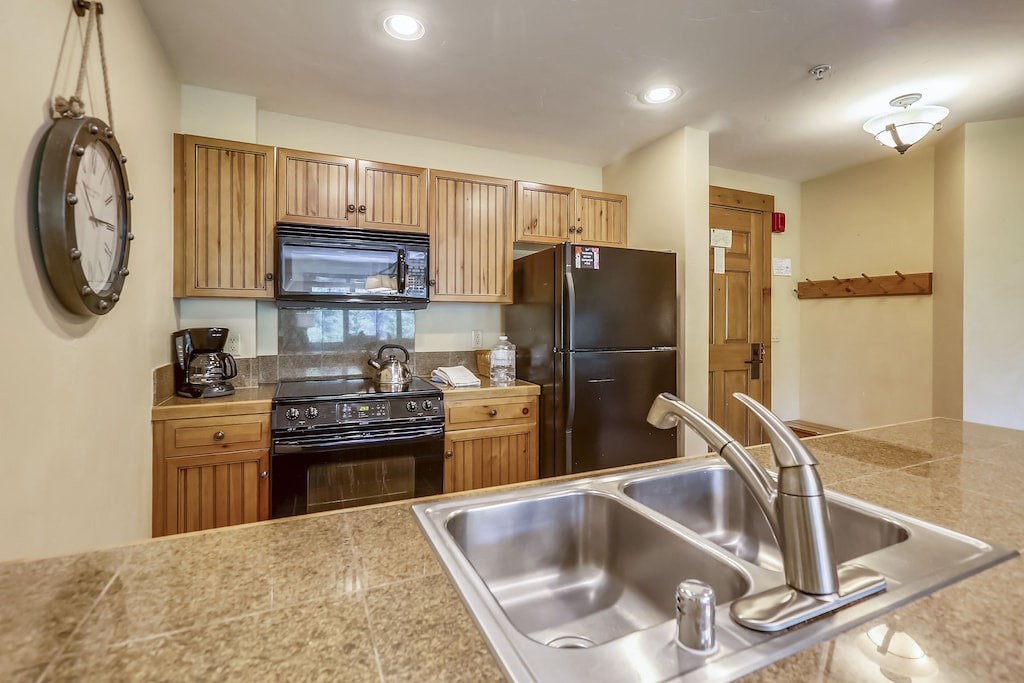 Your fully equipped kitchen awaits with warm wood cabinets, granite counters, and modern appliances for memorable meals together.