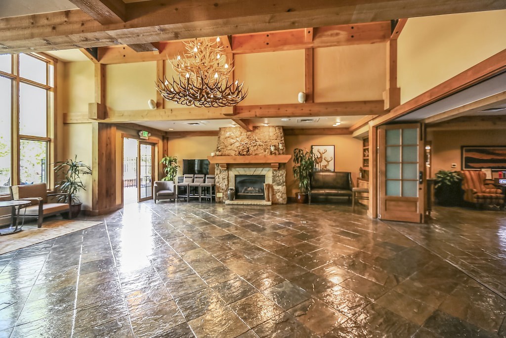 Step into this stunning lodge-style lobby where rustic wood beams meet elegant stone floors, creating your perfect mountain retreat welcome.