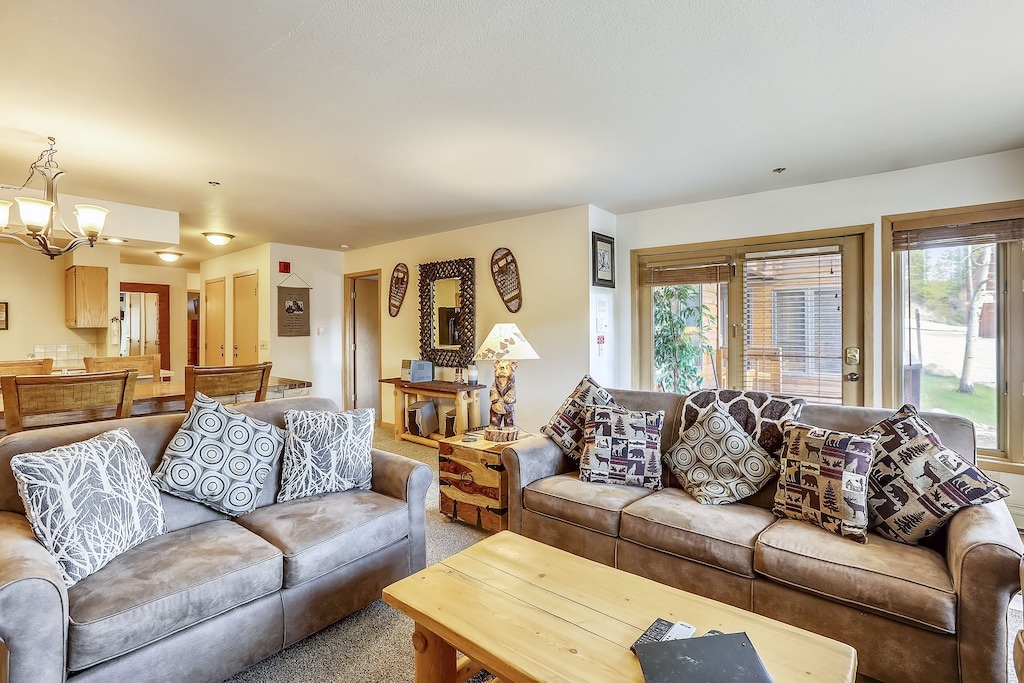 Settle into plush leather sofas surrounded by mountain-themed décor and natural light streaming through patio doors to your outdoor space.