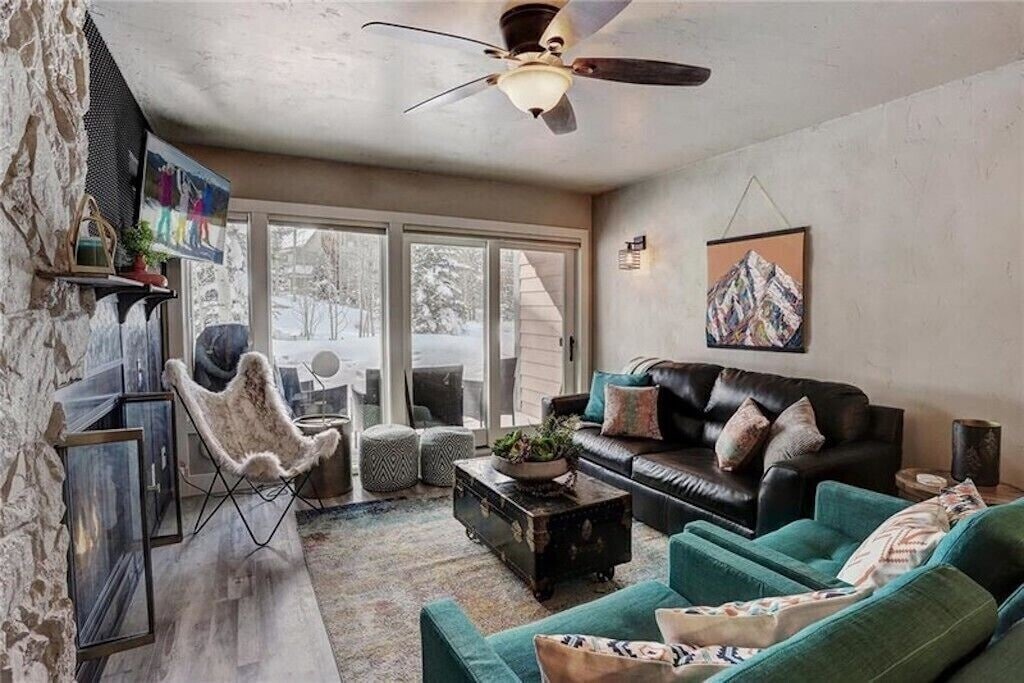 Cozy up by your stone fireplace while snow falls outside. Modern mountain decor and plush seating create the perfect apres-ski retreat.