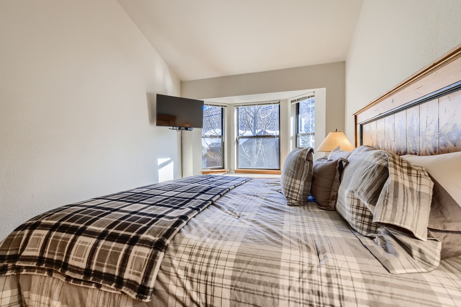 Sink into your cozy plaid bedding and wake to natural light streaming through your windows, creating the perfect mountain retreat atmosphere.