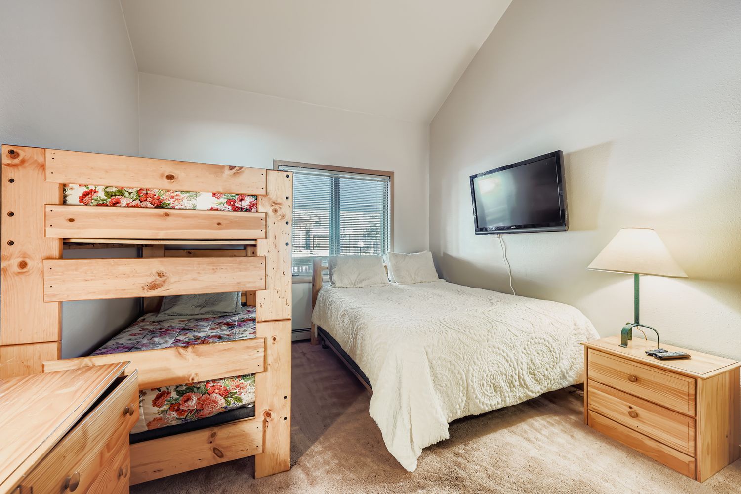 Your comfortable bedroom offers both queen bed and bunk bed, perfect for families, with wall-mounted TV for cozy nights.