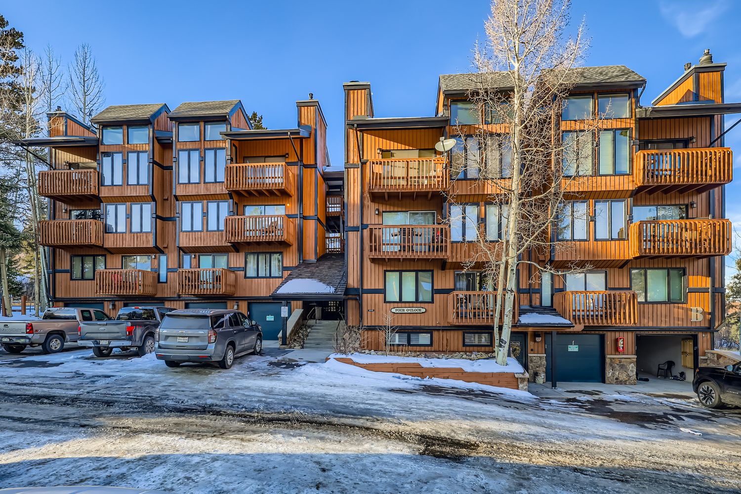 Mountain condominium complex featuring wood-sided buildings with multiple balconies and parking areas.