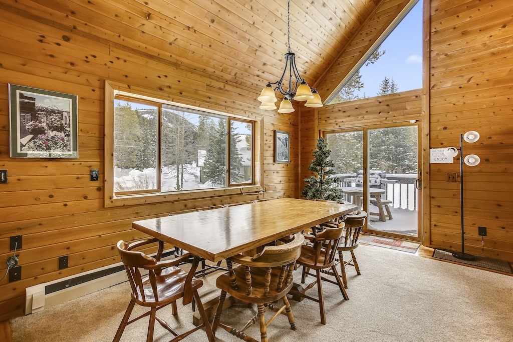 Gather around this warm wooden dining table where mountain views through large windows create perfect backdrops for your memorable meals together.