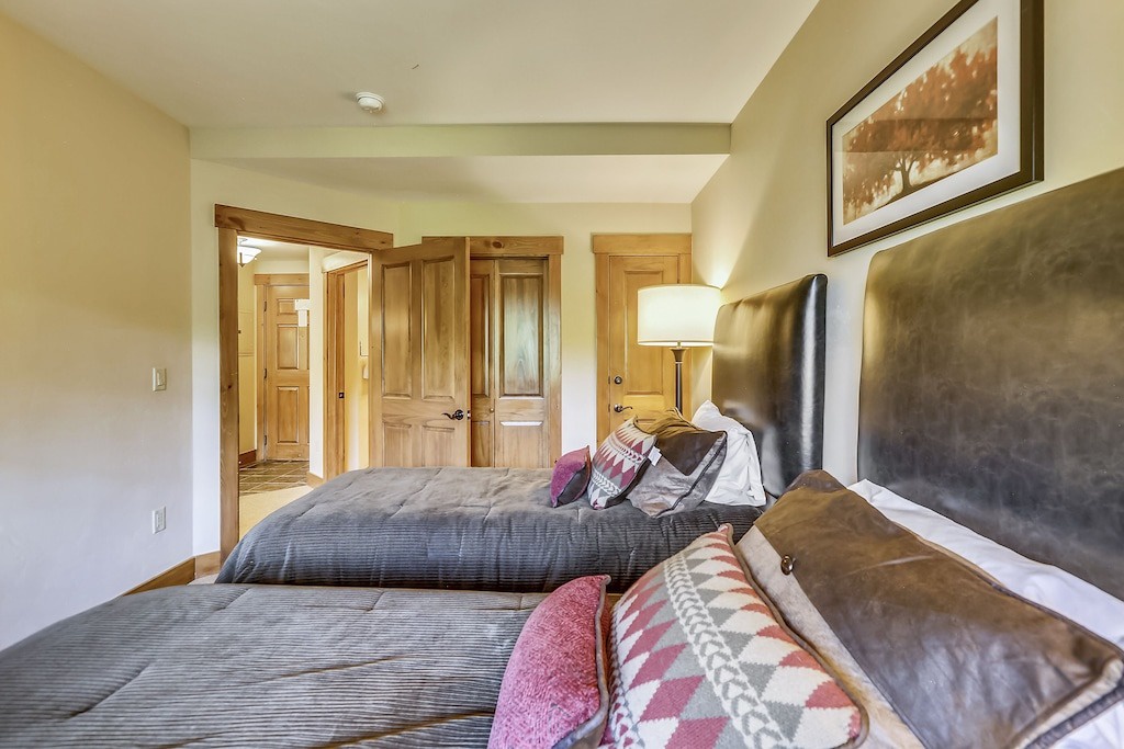 Sink into plush bedding and unwind in your cozy bedroom, where warm wood tones and thoughtful touches create the perfect mountain retreat.