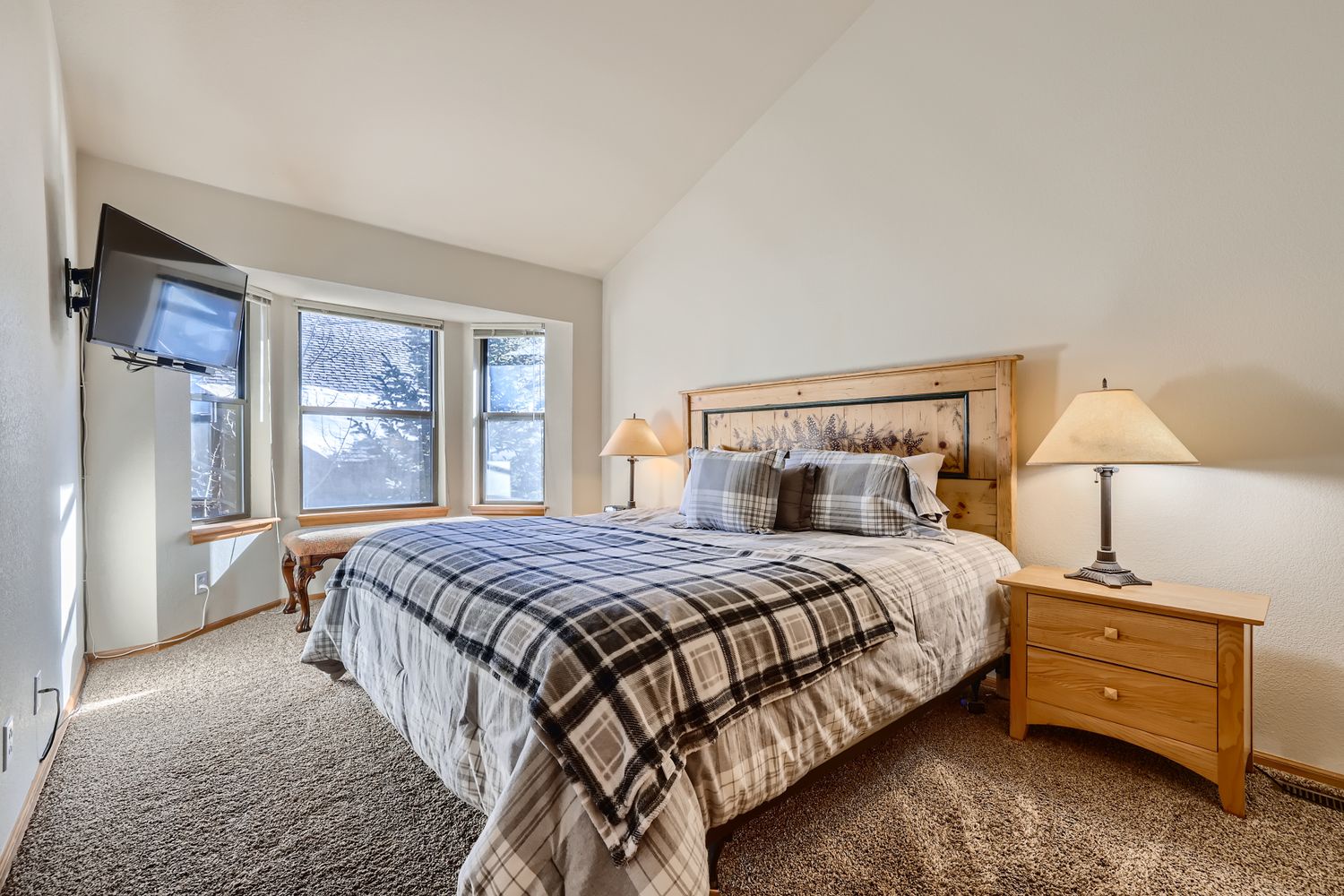 Sink into plaid comfort in your master bedroom, complete with mountain views and TV for cozy evenings in.