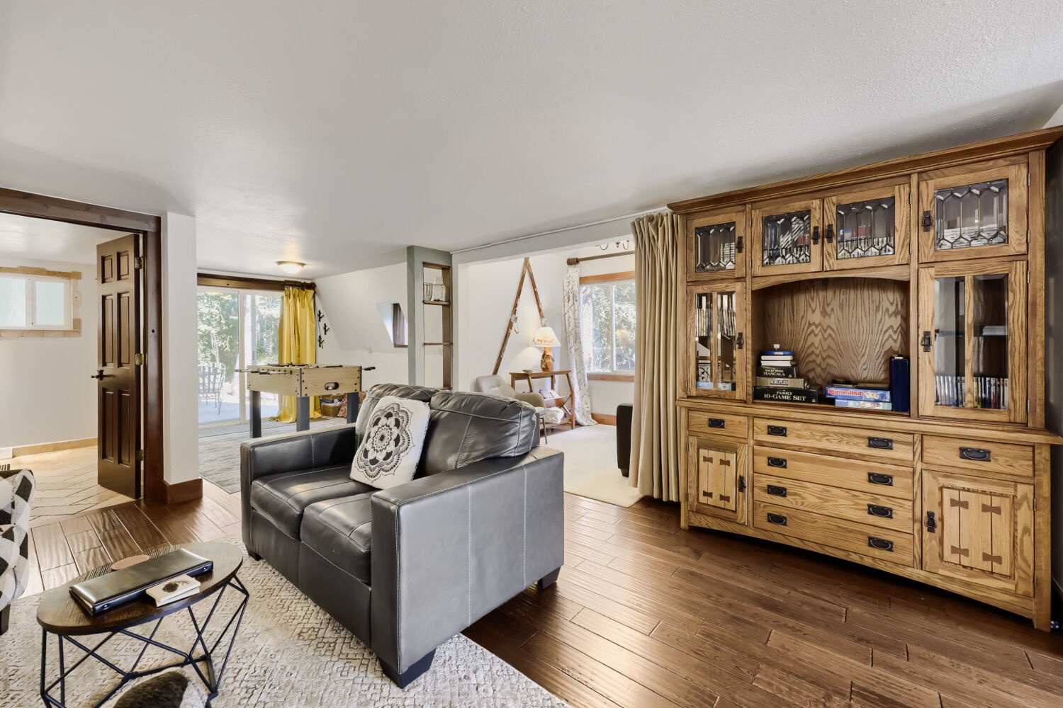 Settle into this inviting living room where rustic wood meets modern comfort. You'll love the open flow to other spaces and the warm natural light from multiple windows.
