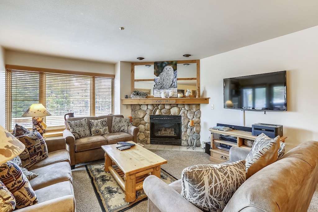 Sink into plush sofas by the stone fireplace while you watch your favorite shows on the flat-screen TV in this inviting living room.