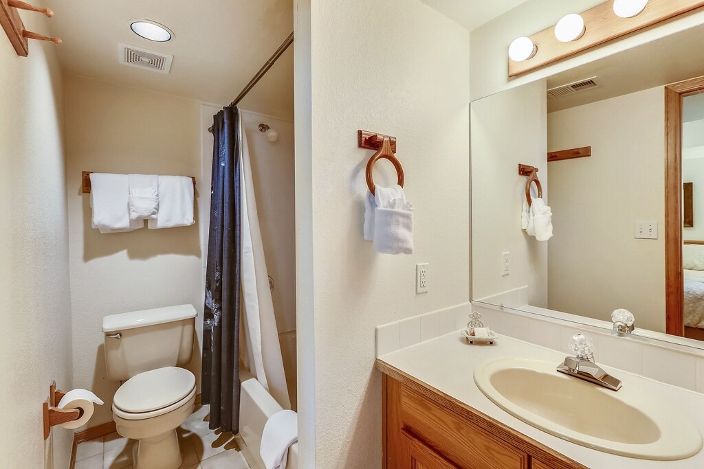 Your private bathroom features thoughtful amenities and warm wood accents for a comfortable stay.