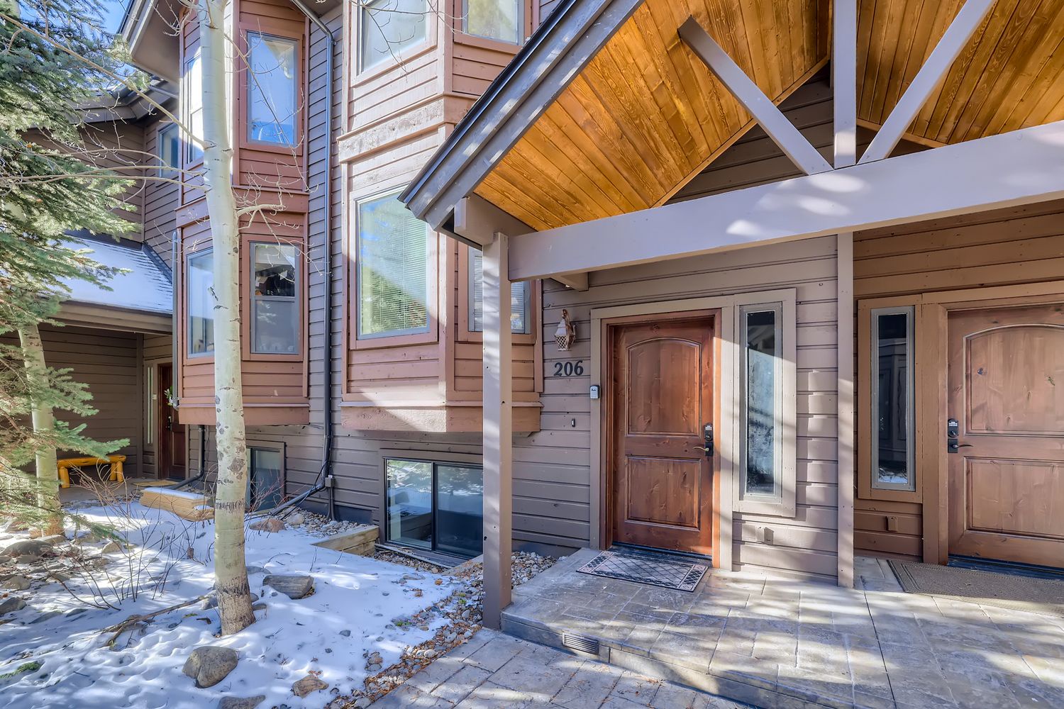 Warm wooden facade welcomes guests to this mountain retreat, where natural materials and thoughtful design create an inviting winter sanctuary.