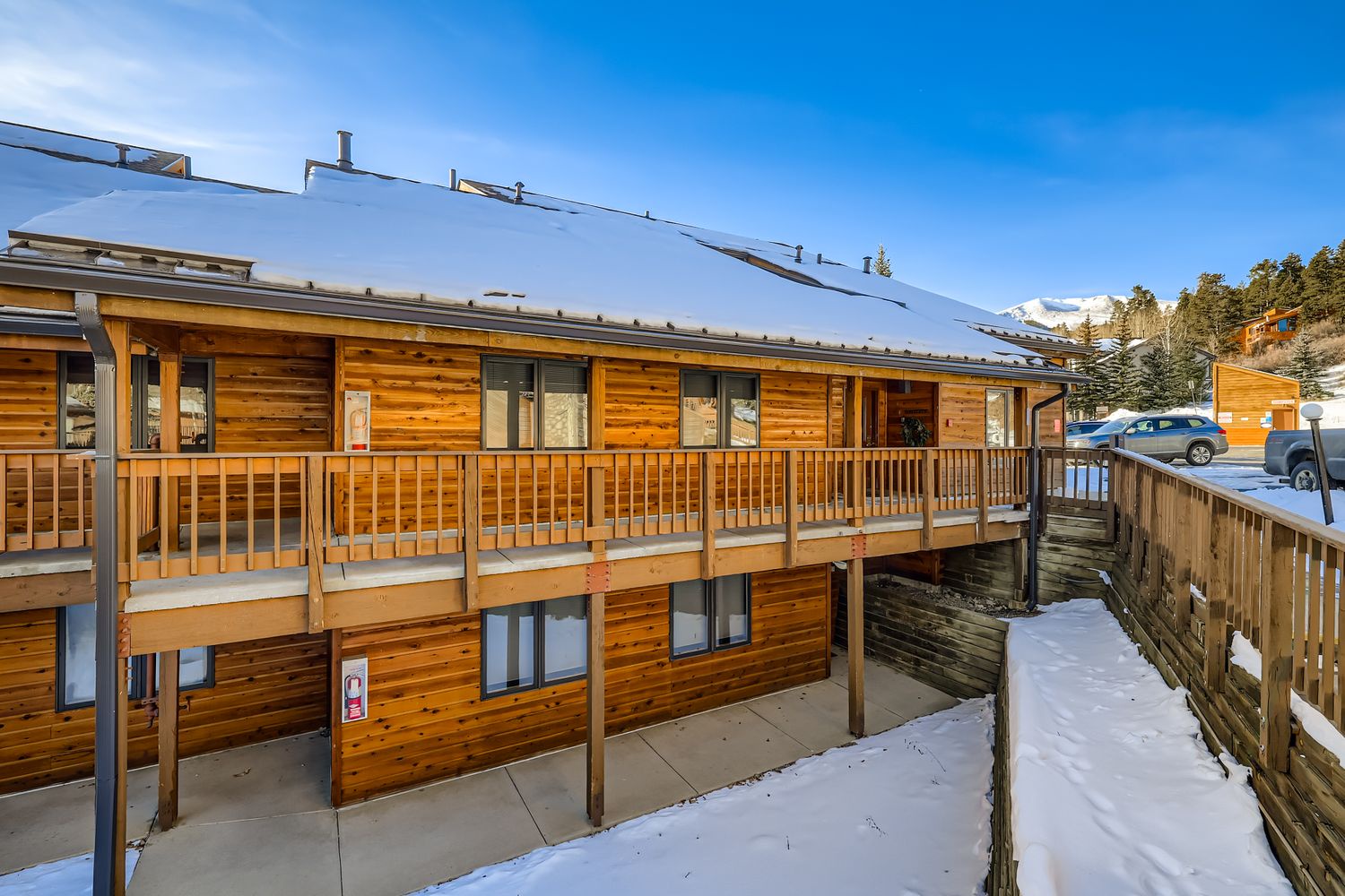 Alpine lodge with wooden balconies and snowy mountain backdrop creates the perfect winter retreat setting.