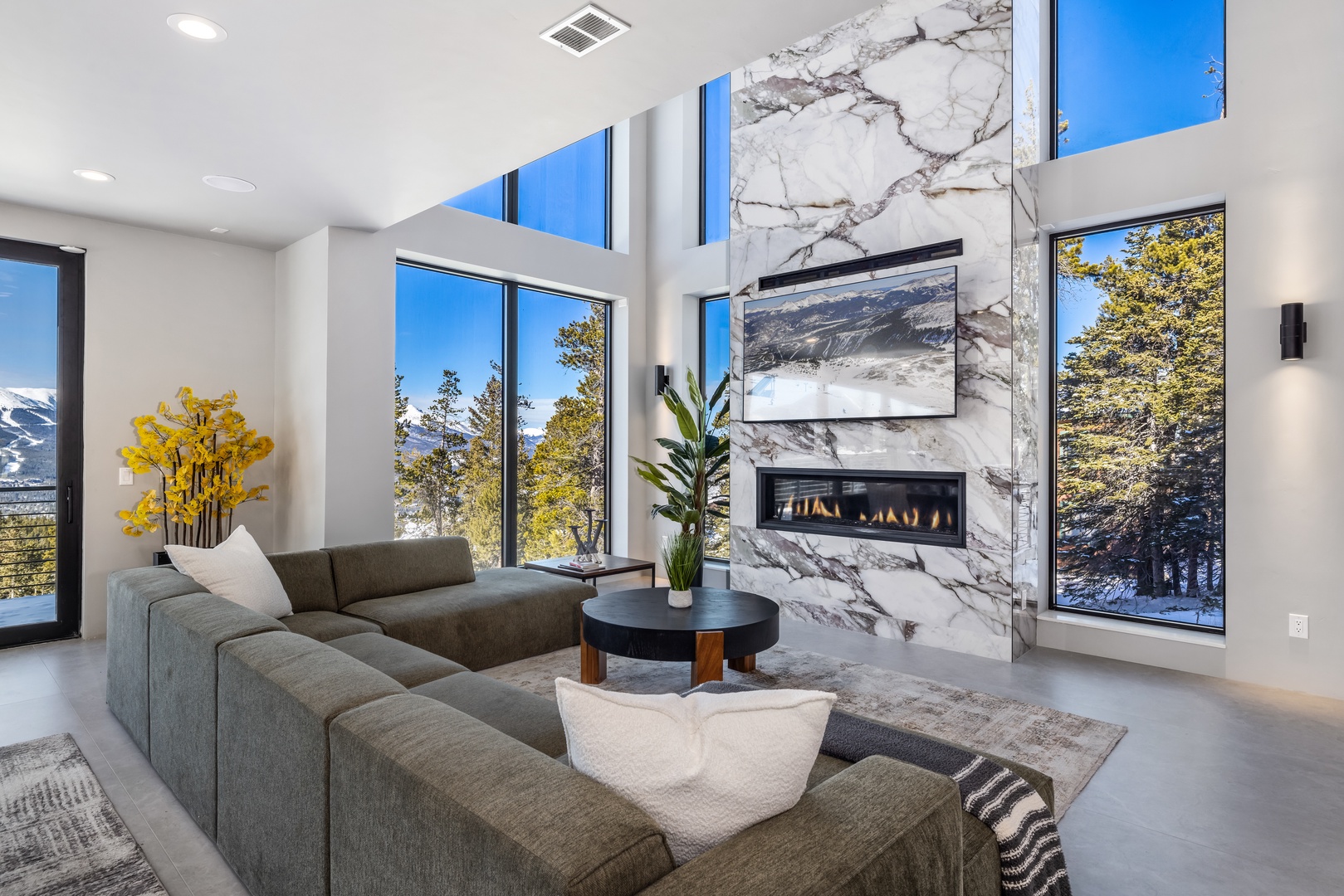 Relax in your bright living space with marble fireplace, mountain views, and modern comfort for the perfect alpine getaway.