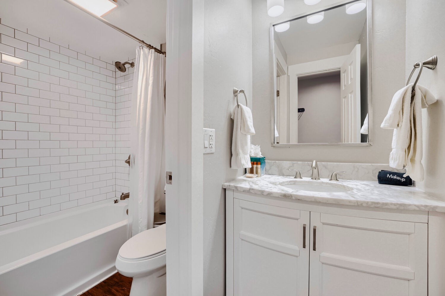 Unwind in your immaculate bathroom, featuring a chic subway-tiled shower, modern fixtures, and a sleek vanity with soft lighting—perfect for refreshing after exploring the area.