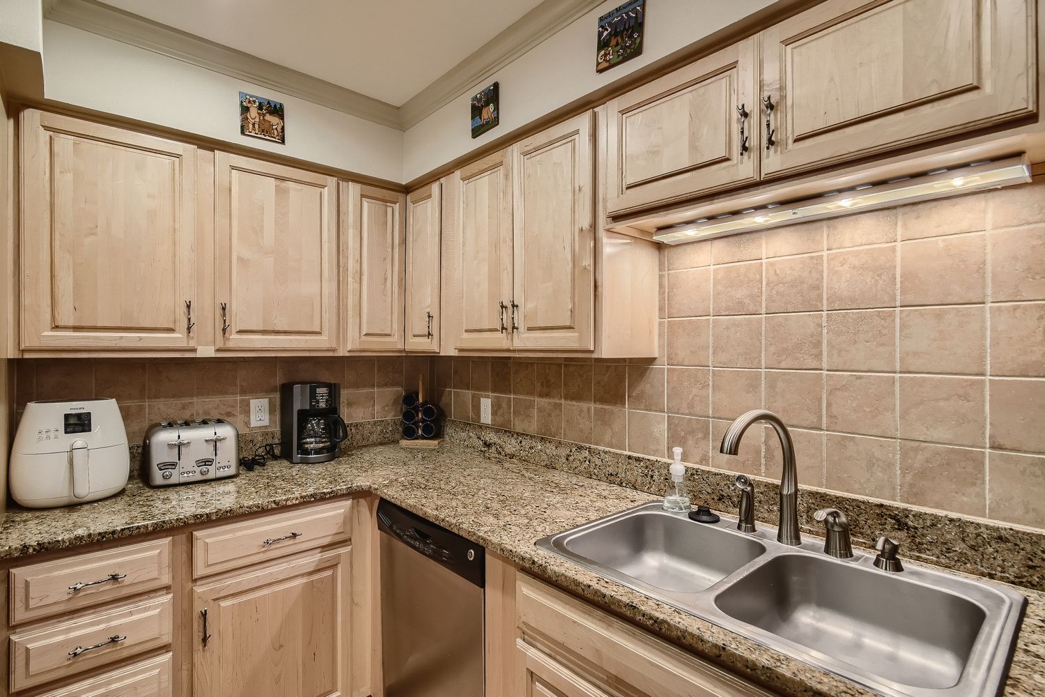 Your fully equipped kitchen features granite countertops, warm wood cabinetry, and modern appliances for preparing memorable meals during your stay.