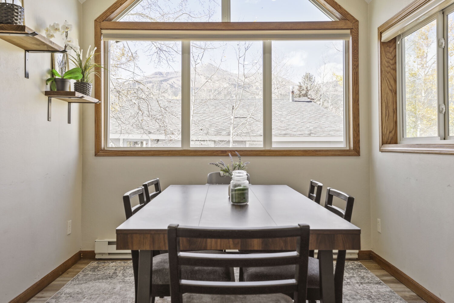Gather around the dining table with soaring windows that frame peaceful mountain views, where natural light and serene surroundings make every meal feel special.