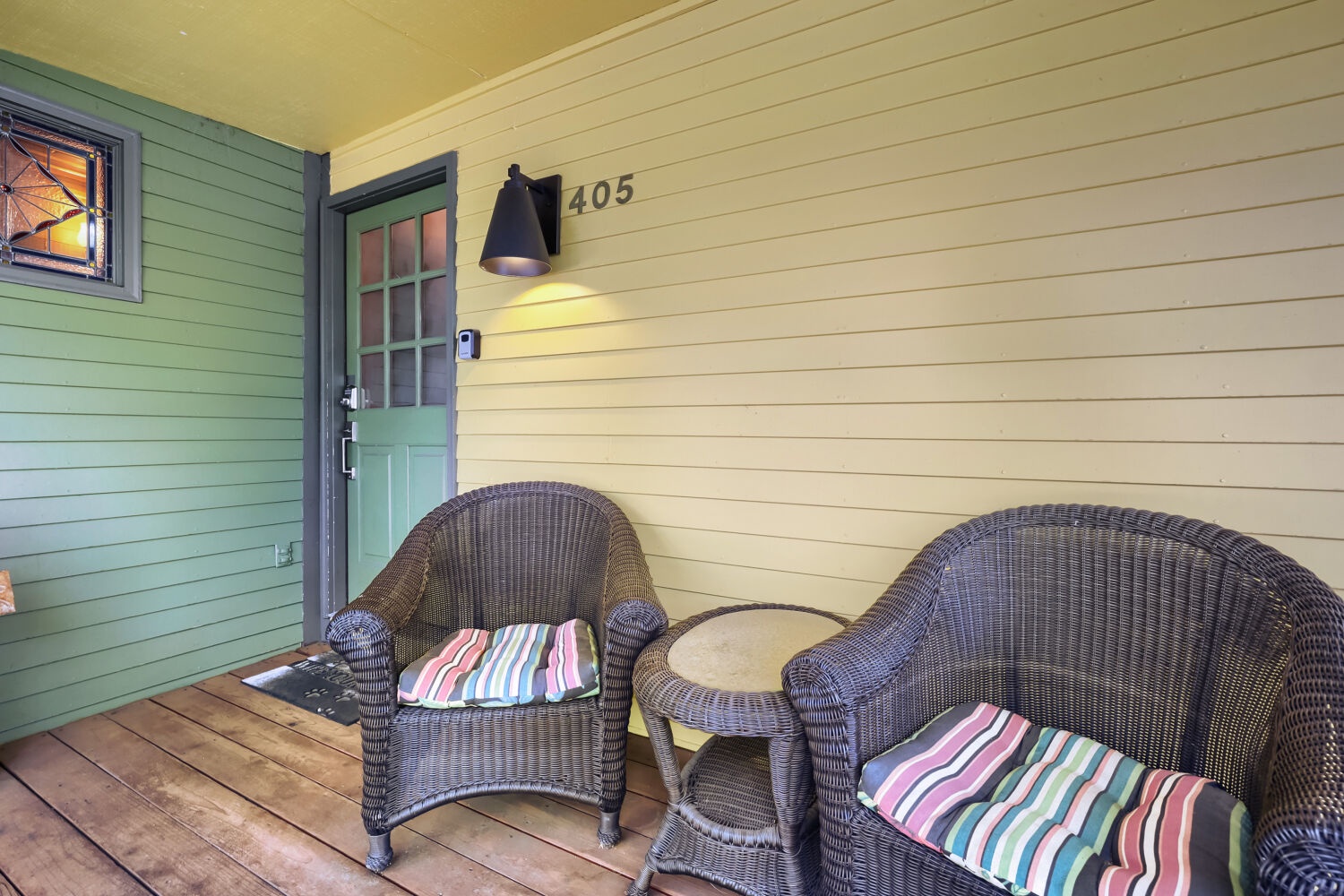 Your private porch invites quiet mornings with coffee, offering cozy wicker seating just steps from your front door.