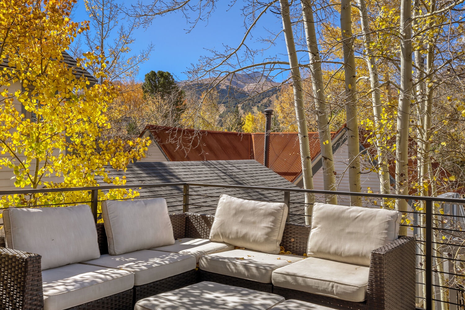 A secluded mountain retreat surrounded by aspens dressed in brilliant autumn gold, with distant peaks framing your private outdoor escape.