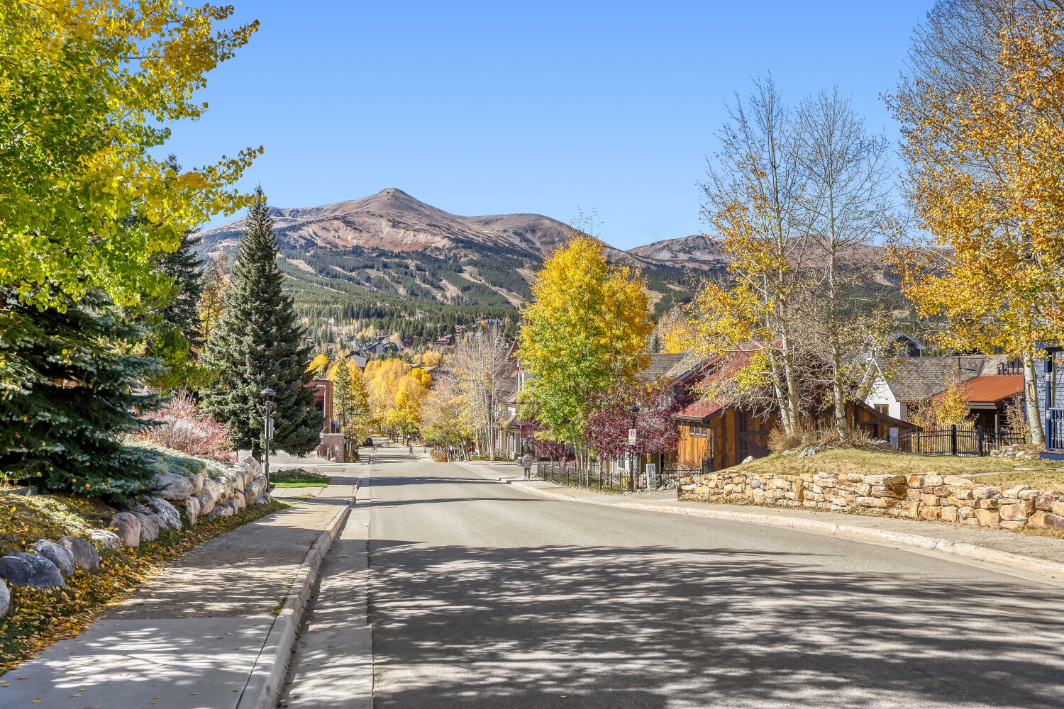A picturesque mountain town setting with autumn colors and residential charm, located in a scenic area surrounded by peaks and natural beauty.