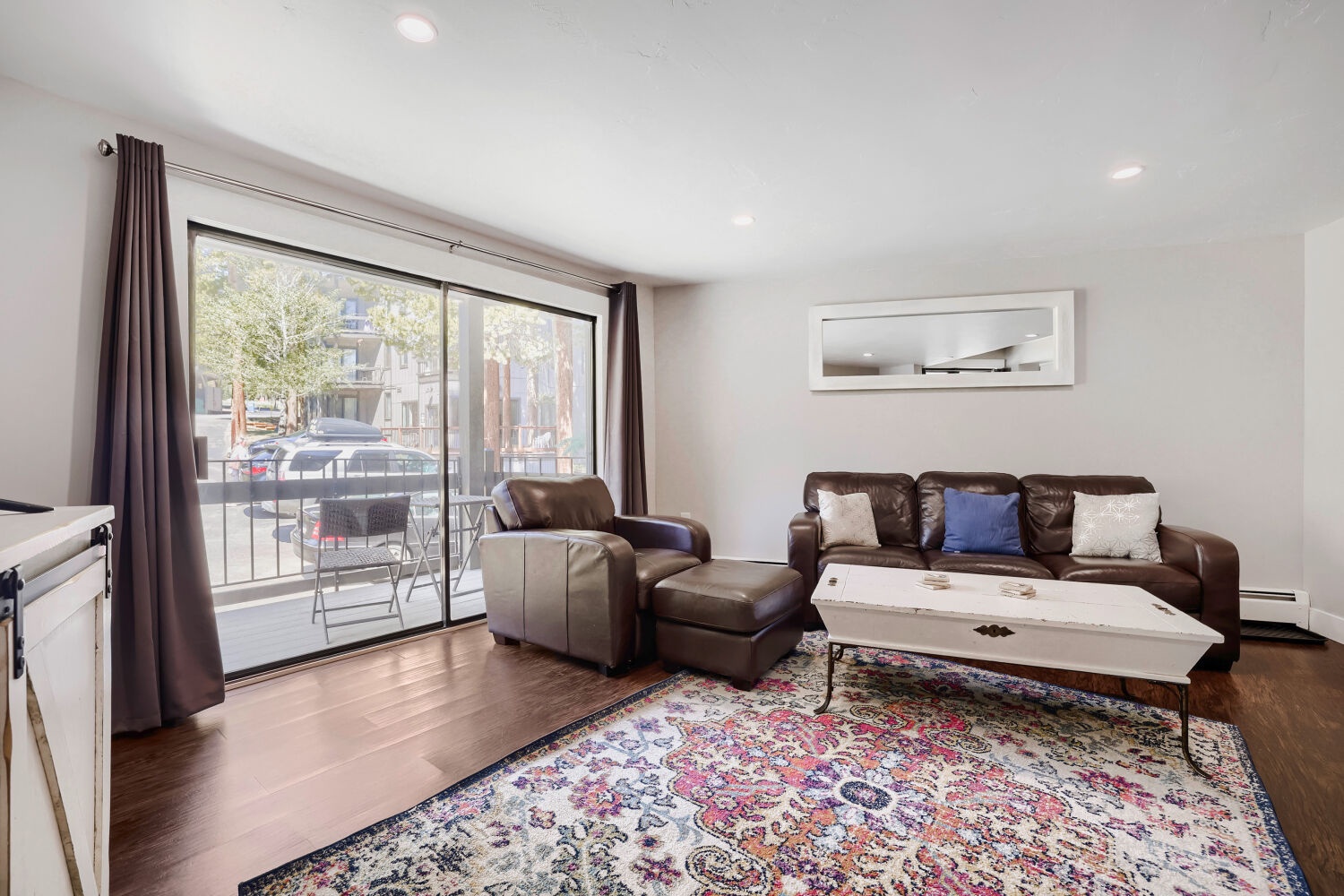 Sink into plush leather seating in your bright living room, where warm hardwood floors and a private balcony invite you to relax and feel right at home.