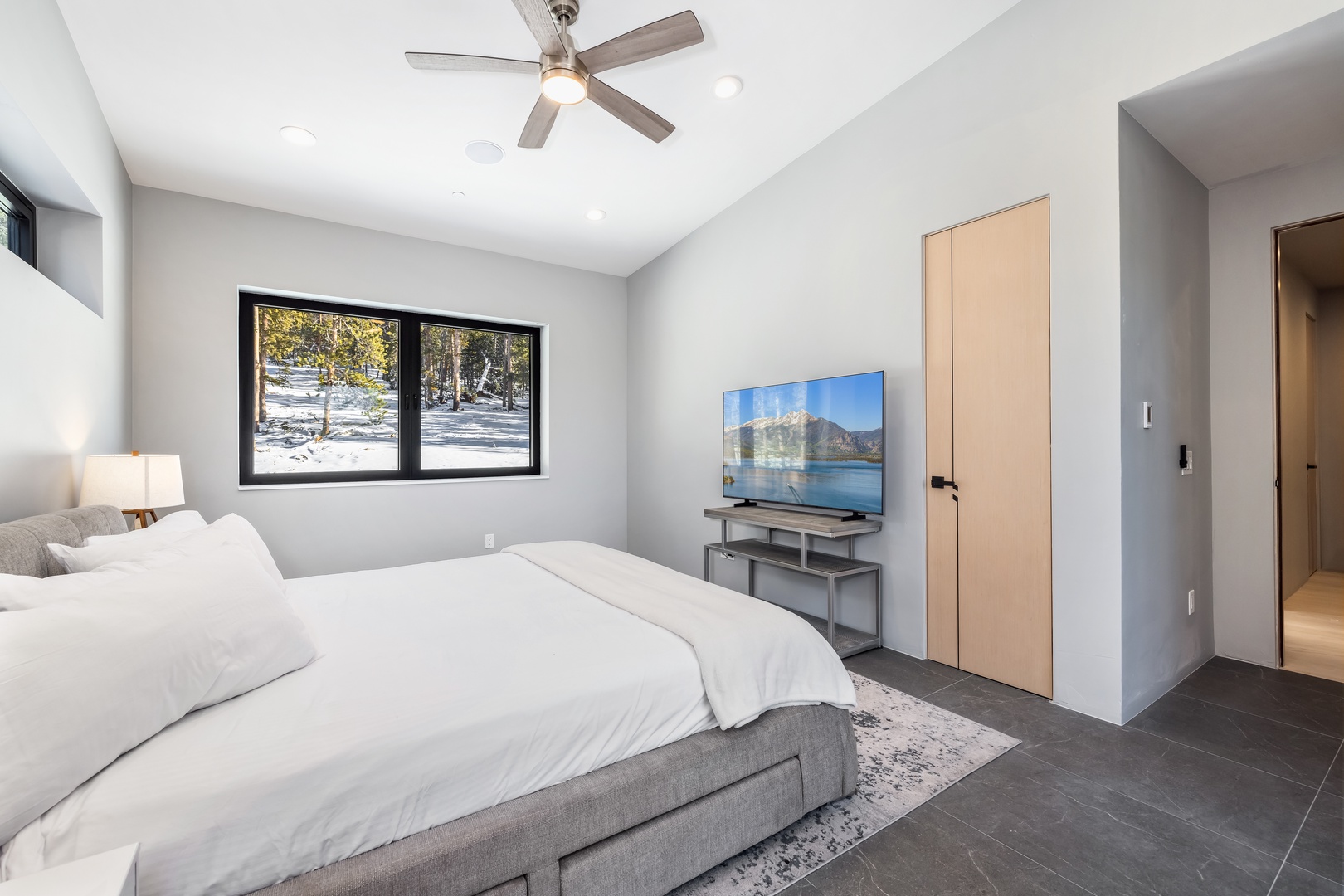 Relax in your modern bedroom with plush bedding, mountain views, and entertainment system for perfect alpine evenings.
