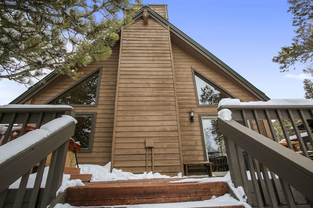 Charming mountain cabin with dramatic A-frame architecture and wooden deck, perfect for your winter getaway retreat.