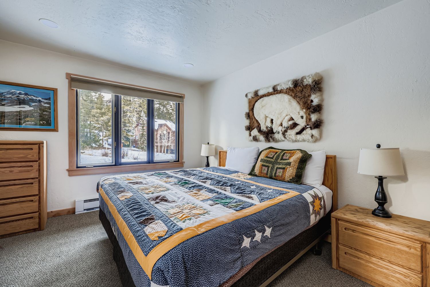 Cozy bedroom with rustic charm featuring a comfortable queen bed and peaceful winter forest views through your private window.