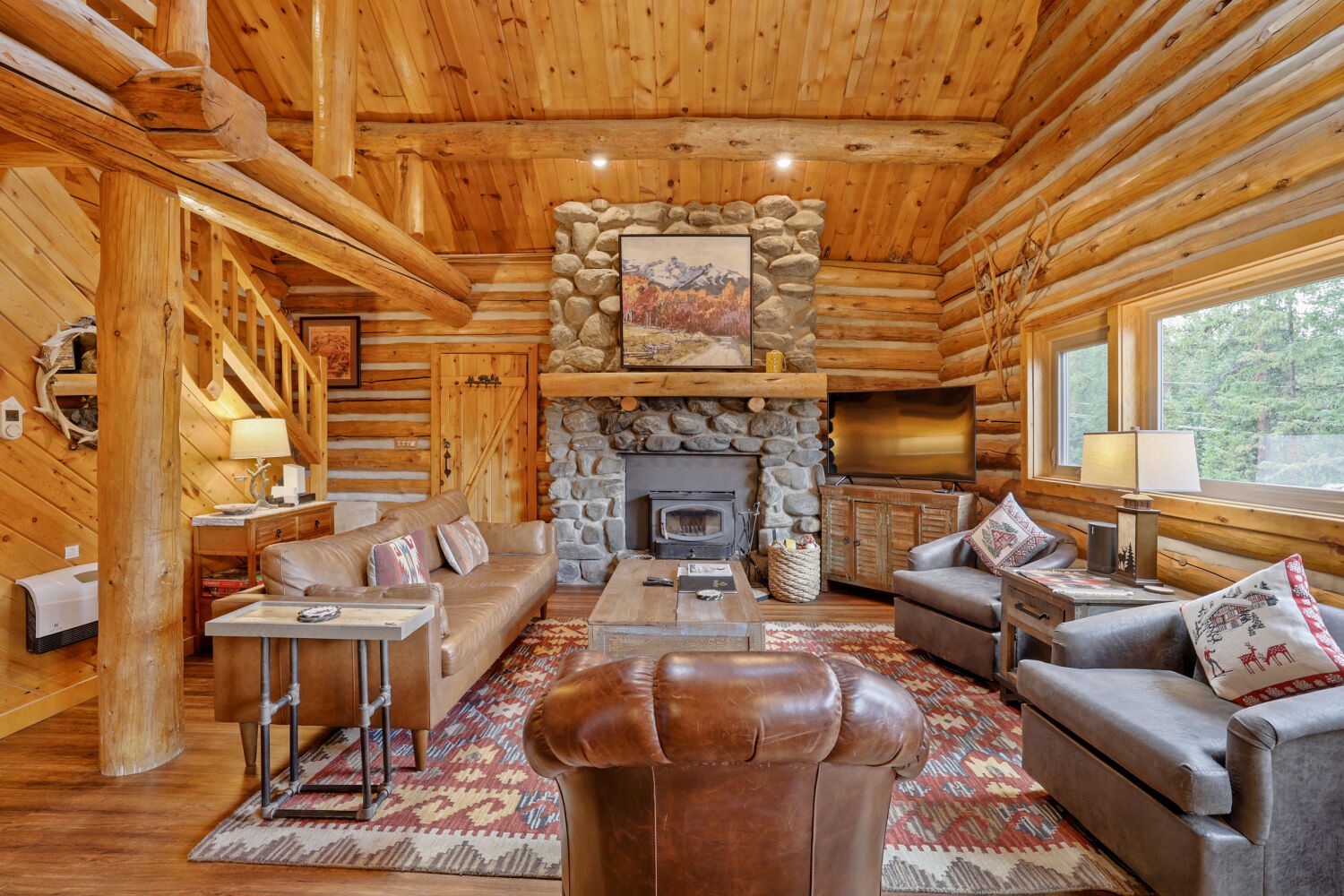 Settle into the warmth of your private log cabin retreat, where handcrafted wood beams soar overhead and a stone fireplace invites you to unwind after mountain adventures.