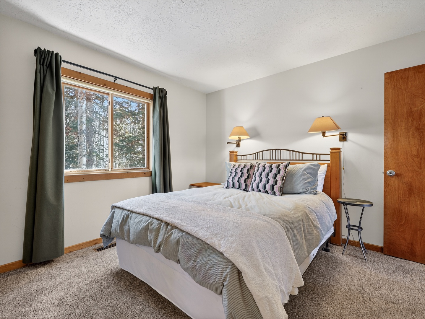 Drift off in your peaceful bedroom, where warm wood accents and forest views through the window create the perfect mountain retreat sanctuary.