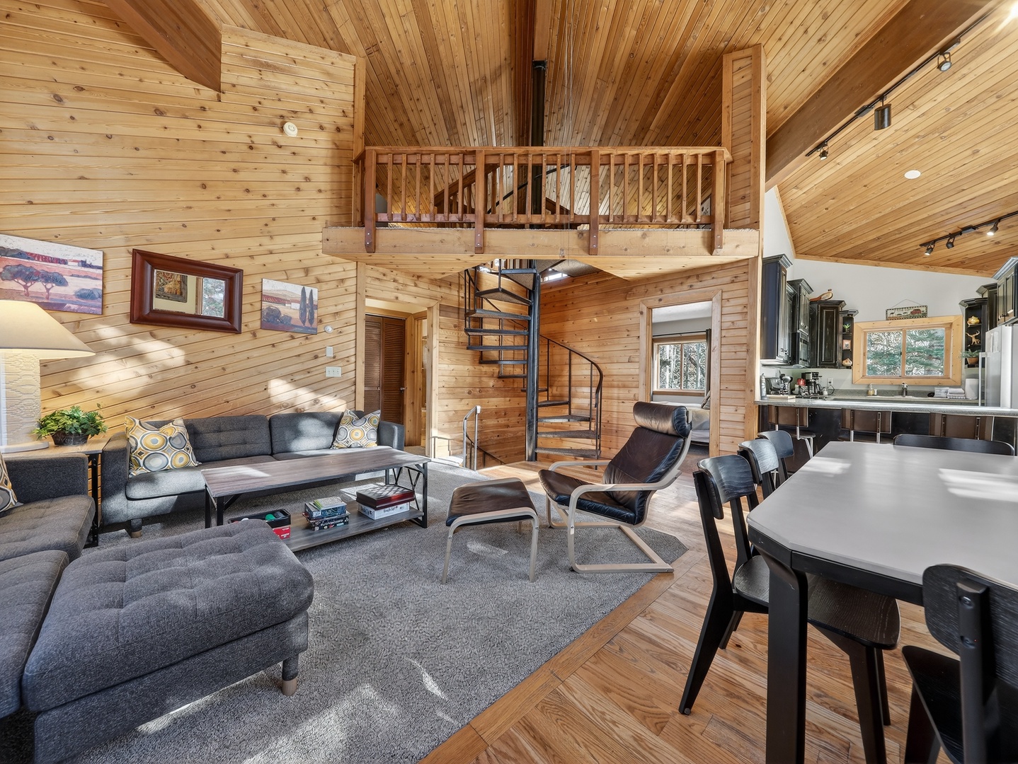Relax in your modern cabin retreat with soaring wood ceilings, cozy seating, and a loft above for peaceful getaways.