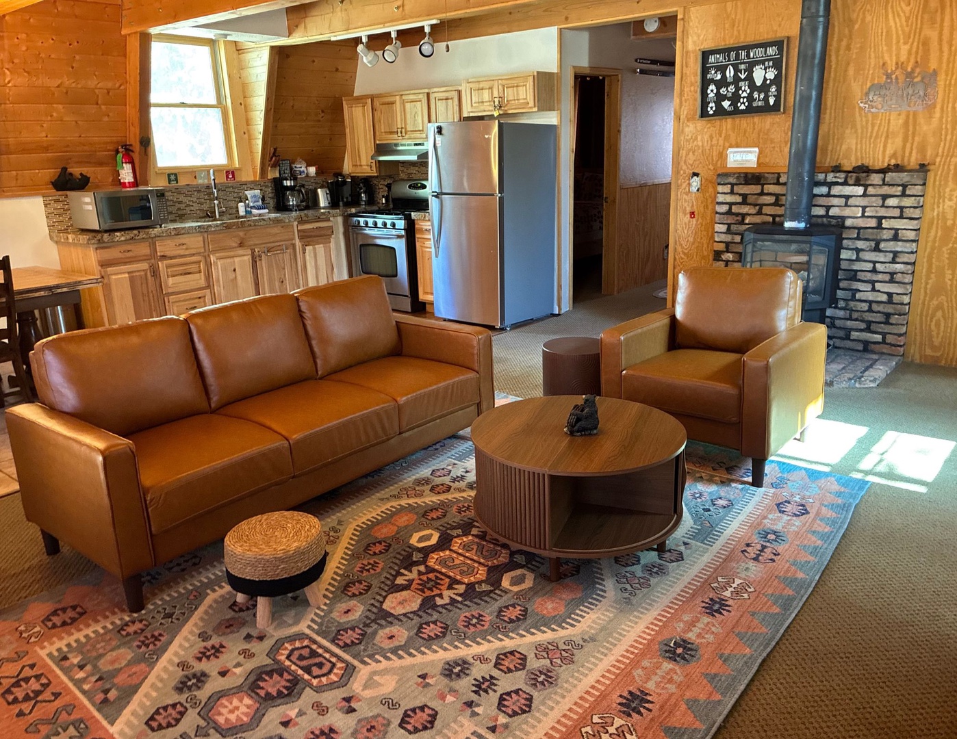 View of the living room, featuring a 55" Smart TV, comfortable couch, and views of the trees
