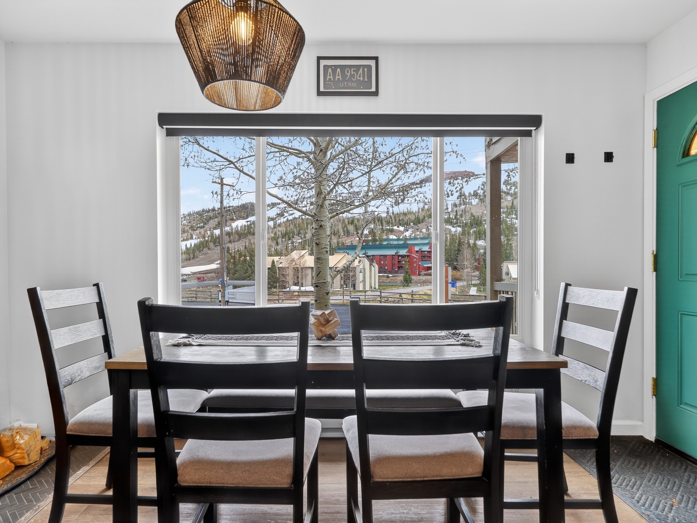 Gather around this stylish dining table where mountain town views frame every meal. Natural light pours through expansive windows, highlighting the cozy neighborhood charm just beyond your retreat.