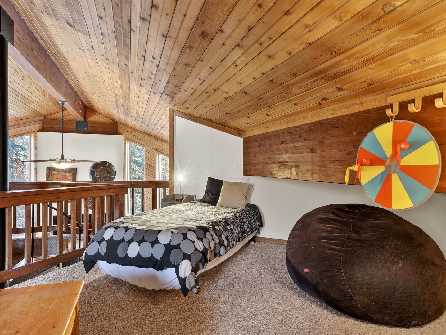 Unwind in your cozy loft bedroom with exposed beams, comfortable bedding, and a giant bean bag for ultimate relaxation.