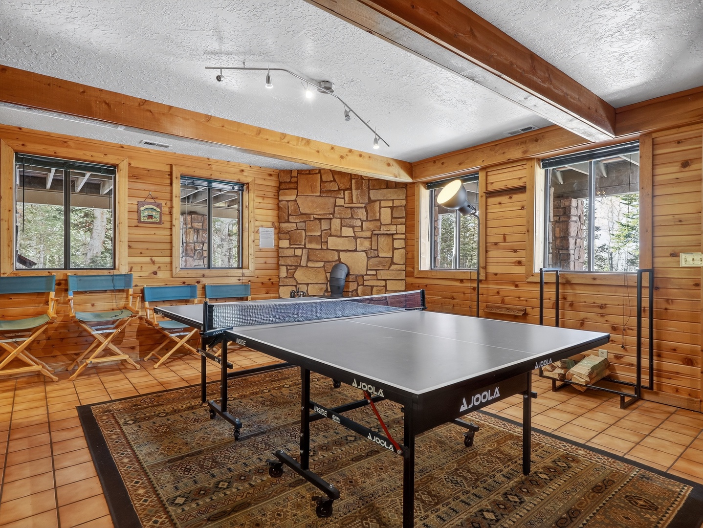 Wood paneled game room with ping pong table and wood burning stove