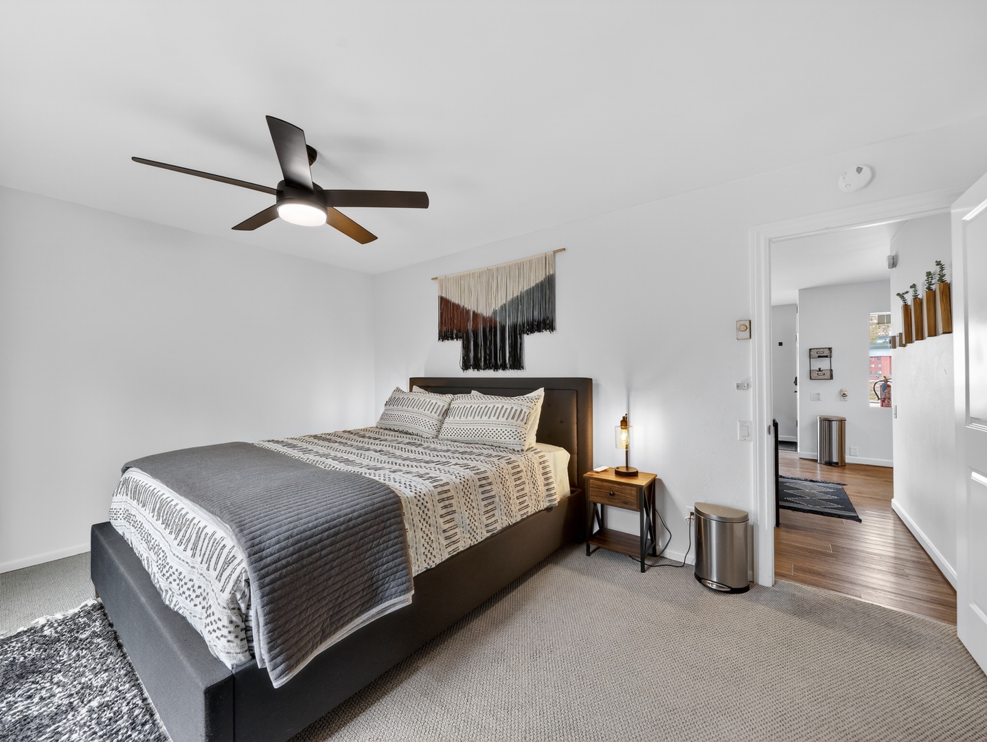 Warm, thoughtfully designed primary bedroom with layered textures and a king bed