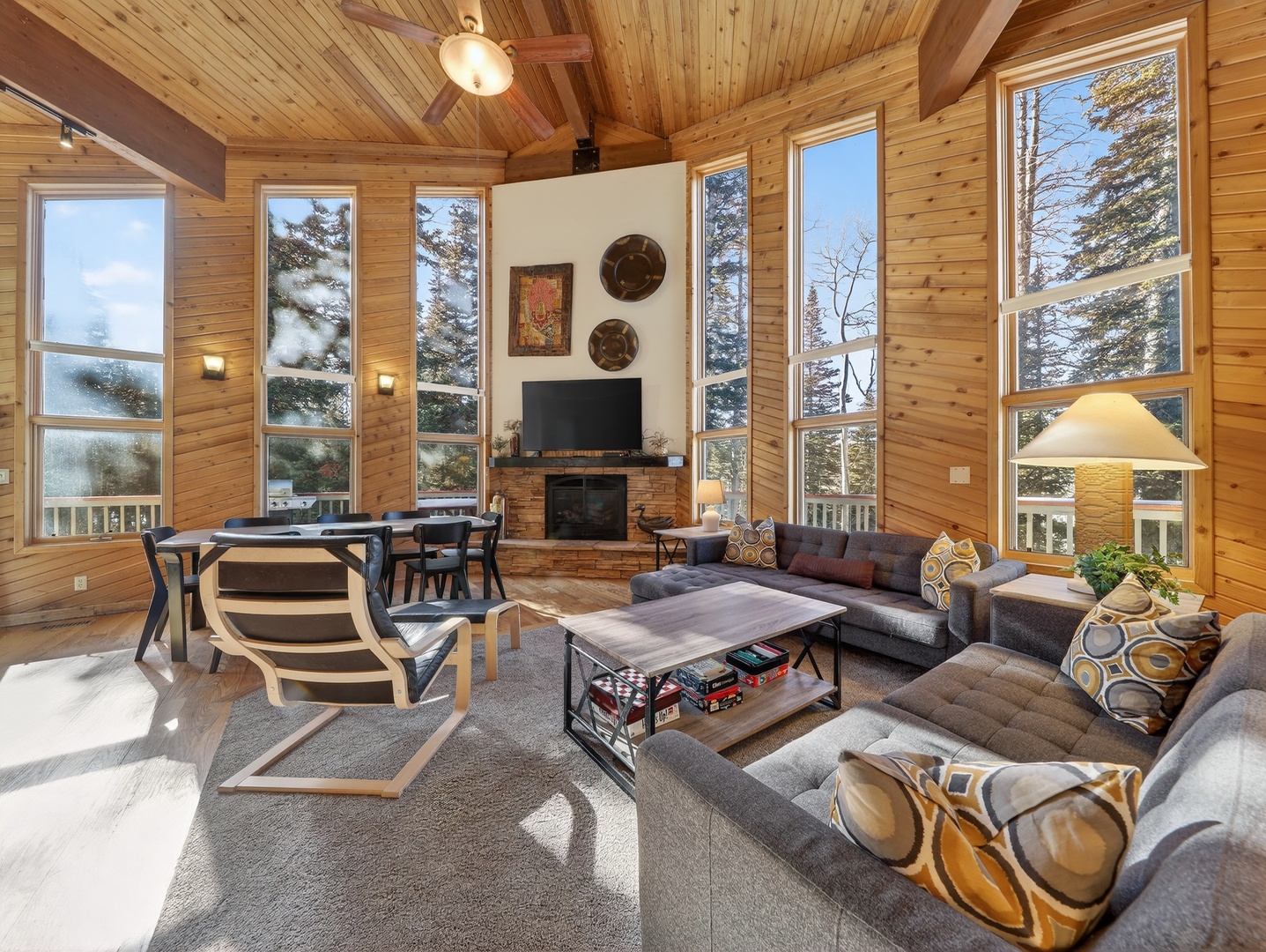 Expansive great room with floor-to-ceiling windows and sweeping views of the surrounding forest and mountains.