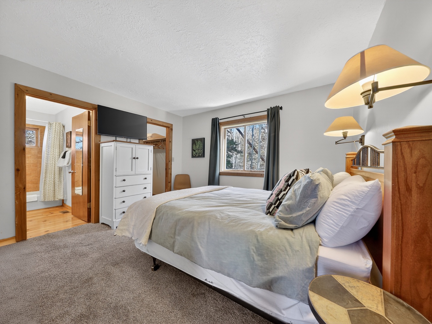 Sink into crisp linens and drift off to peaceful forest views. Your private bedroom sanctuary features warm wood touches and gentle lighting.