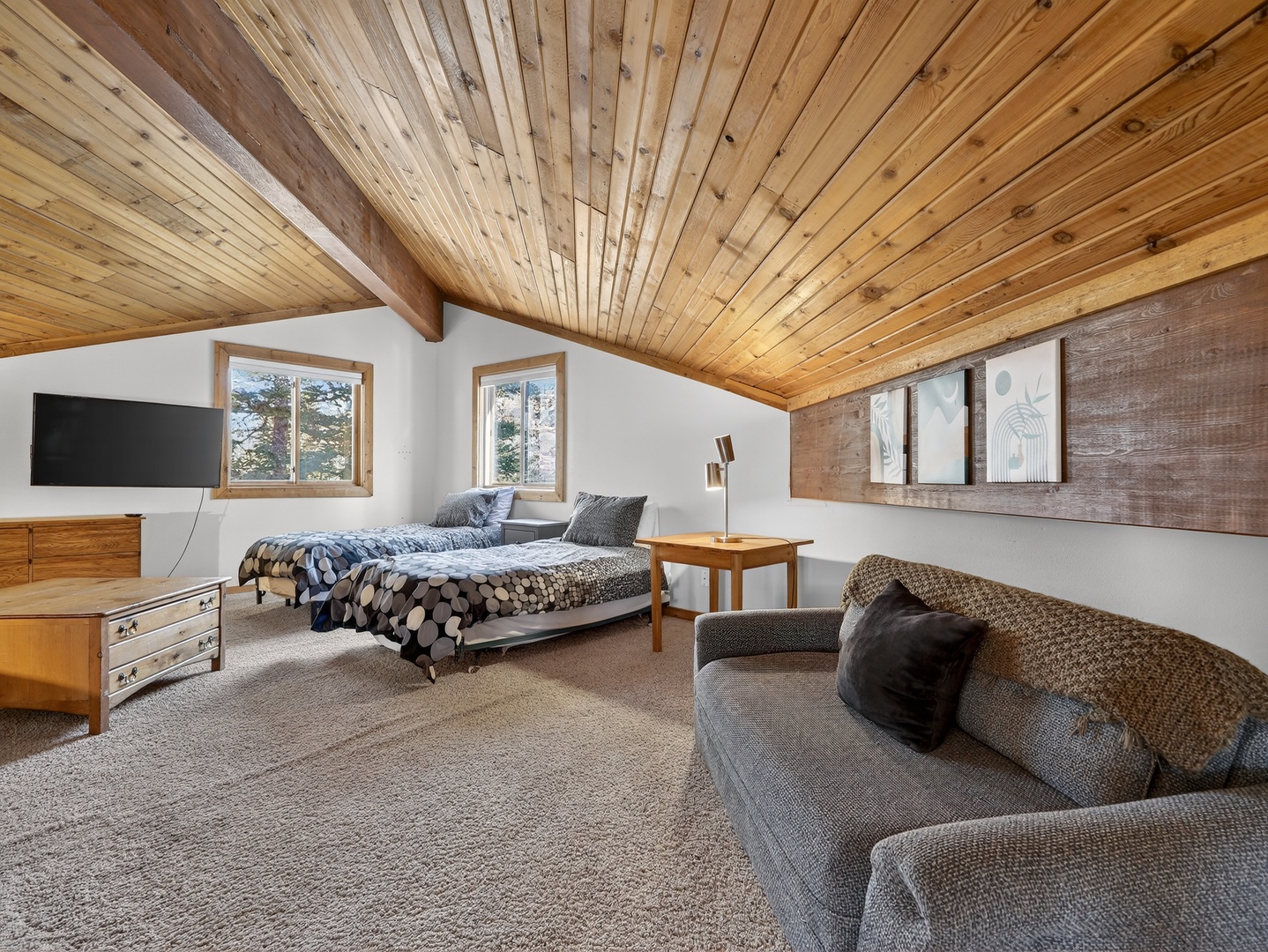 Your cozy alpine loft features warm wood ceilings, comfortable seating, and forest views for the perfect mountain retreat.