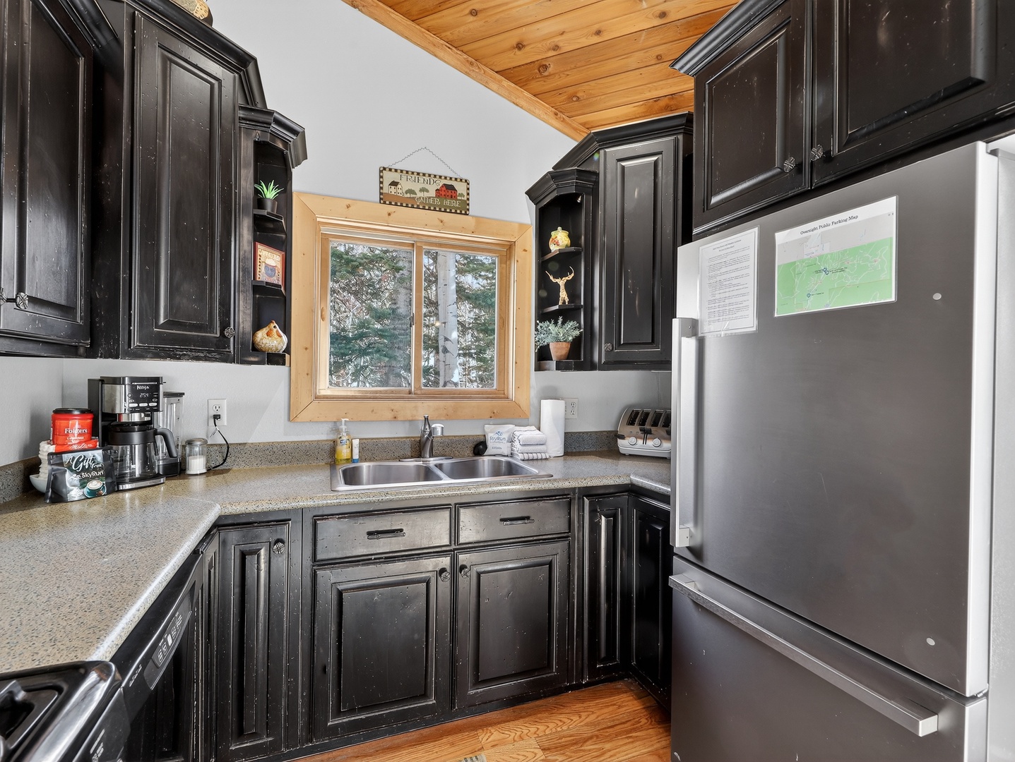 Your fully equipped kitchen features dark cabinetry, modern appliances, and natural light streaming through the window for enjoyable meal prep.