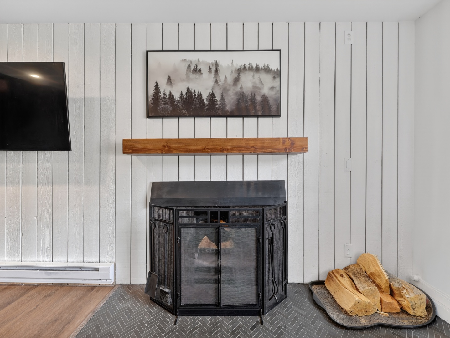 Charming fireplace with rustic wood accents and mountain-inspired decor