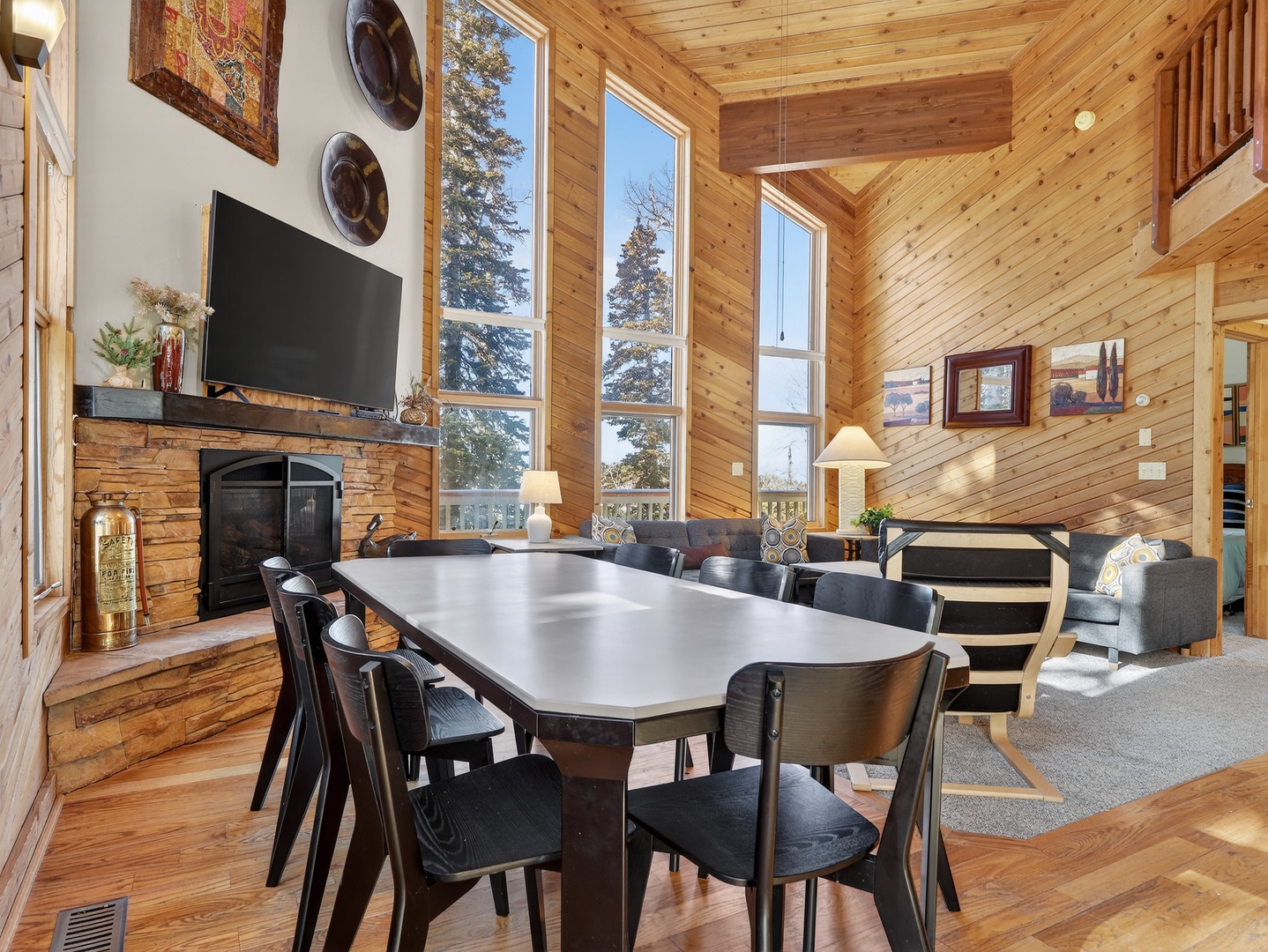 Gather around your spacious dining table with soaring ceilings, cozy fireplace, and mountain views through floor-to-ceiling windows in this warm log cabin retreat.