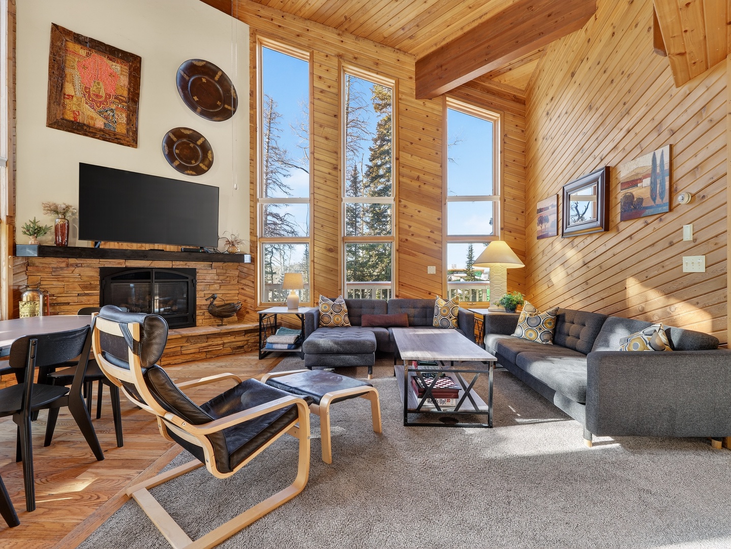 Unwind in your spacious living room featuring warm wood walls, cozy fireplace, and comfortable seating perfect for mountain evenings.