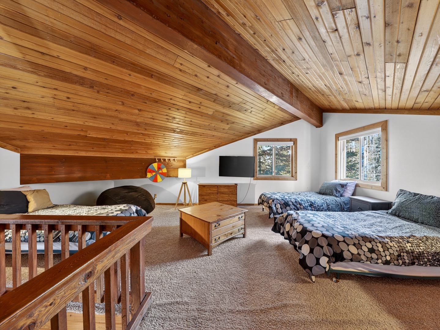 Cozy up in this charming loft bedroom with exposed wood beams and forest views from your private windows.