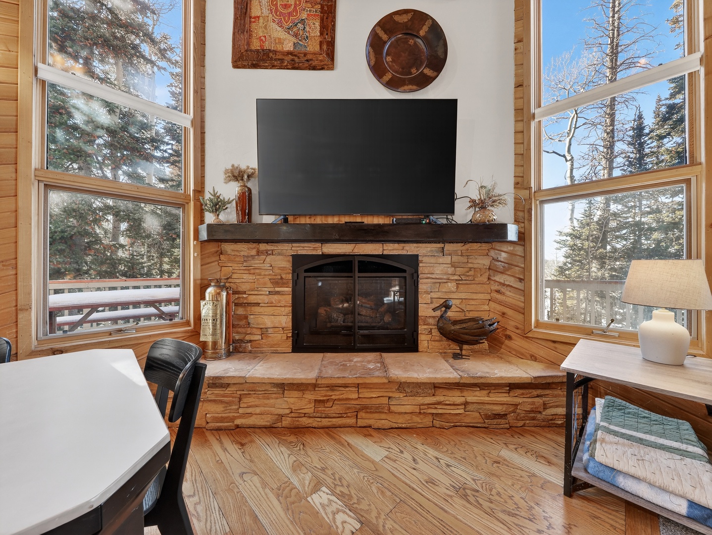 Cozy up by the stone fireplace while enjoying mountain views through floor-to-ceiling windows in your peaceful retreat.